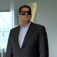 Former head of Nintendo of America, Reggie Fils-Aime walks into a meeting wearing sun glasses.